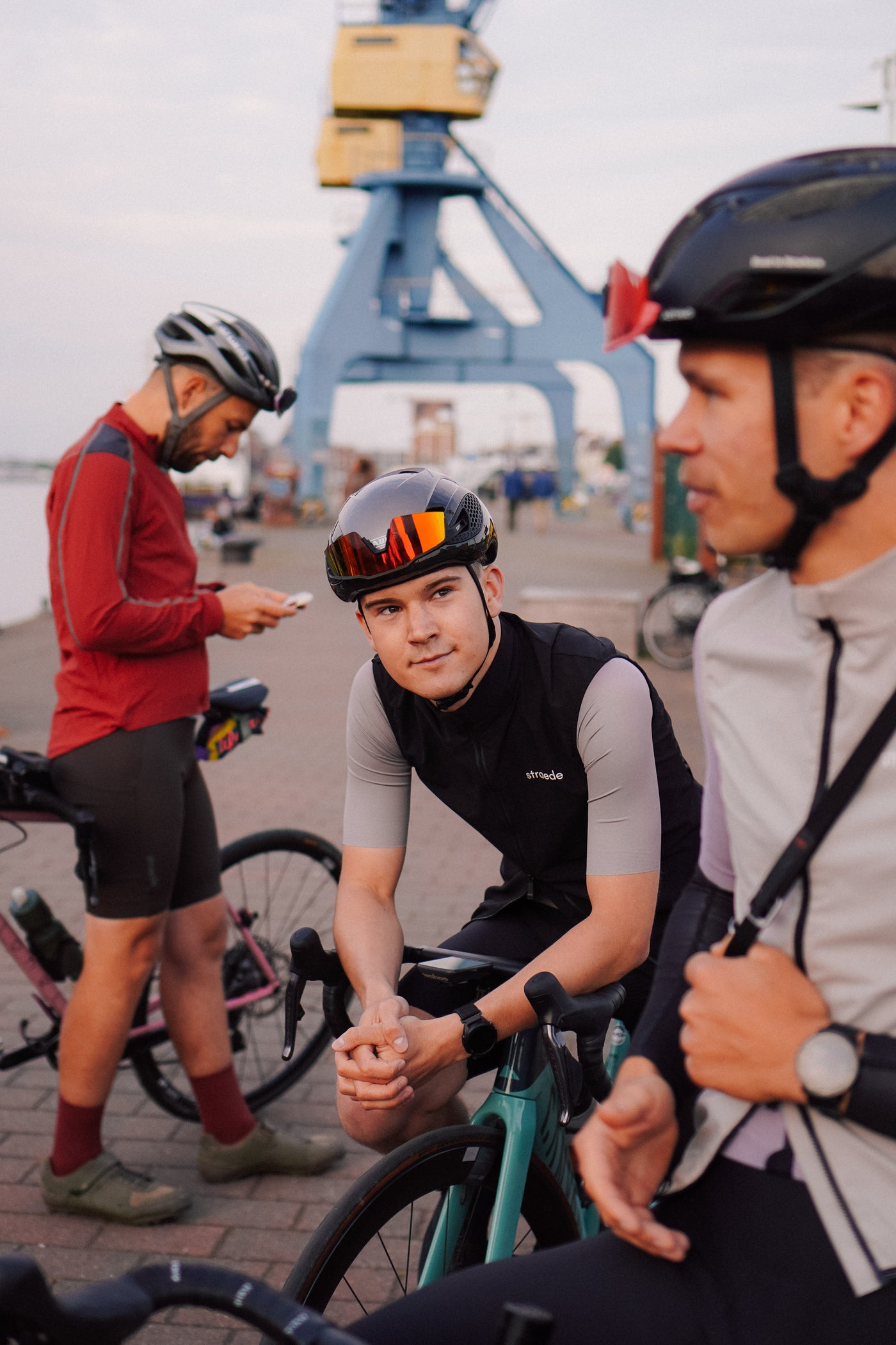 3 Rennradfahrer: Der mittlere trägt eine Rennradweste.