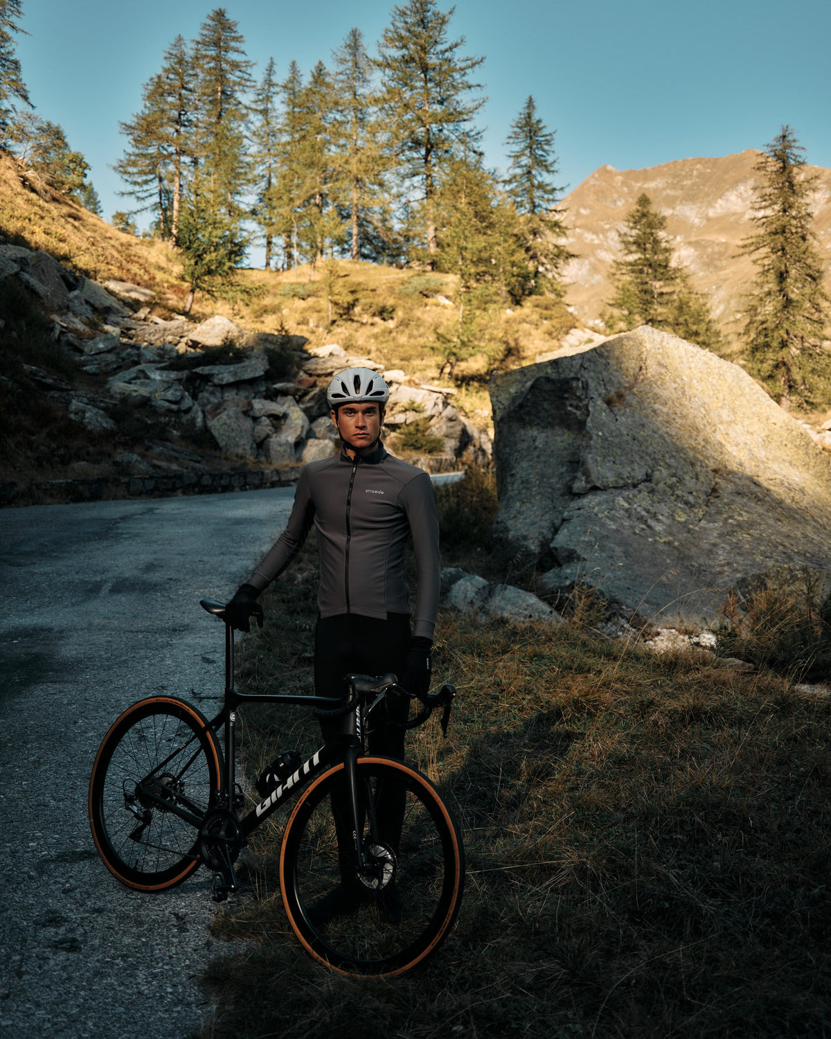 Mann steht in den Bergen und fährt mit seiner Radbekleidung von straede los